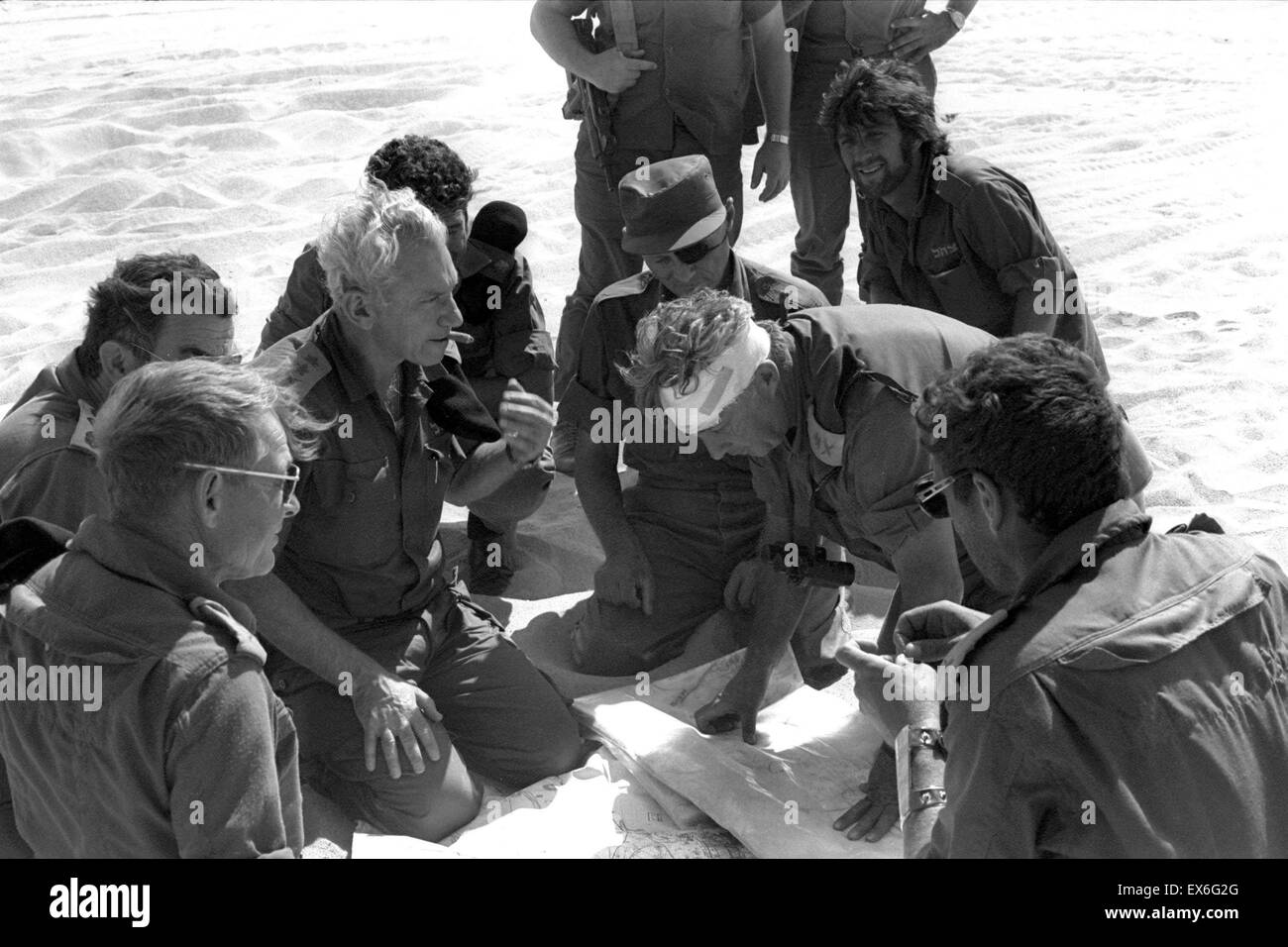 Israeli defence Minister Moshe Dayan (eye patch) General Haim Barlev centre (white hair) General Avraham Adan (left glasses) and General Ariel Sharon (Head bandaged) meet during the 1973 October war in the Middle East Stock Photo