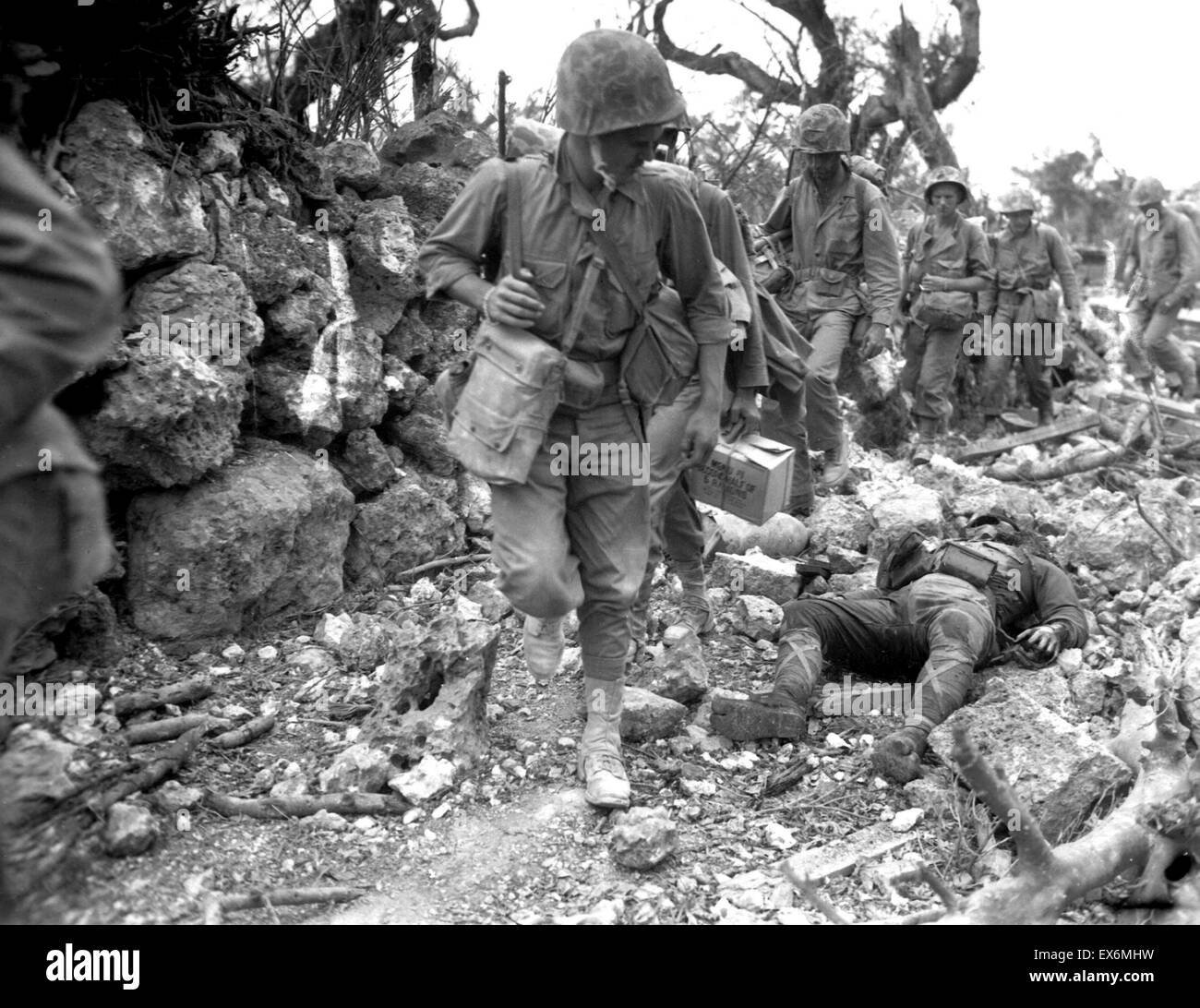 Okinawa U.S. Marines pass a dead Japanese soldier in a destroyed village, during World War two 1945 Stock Photo