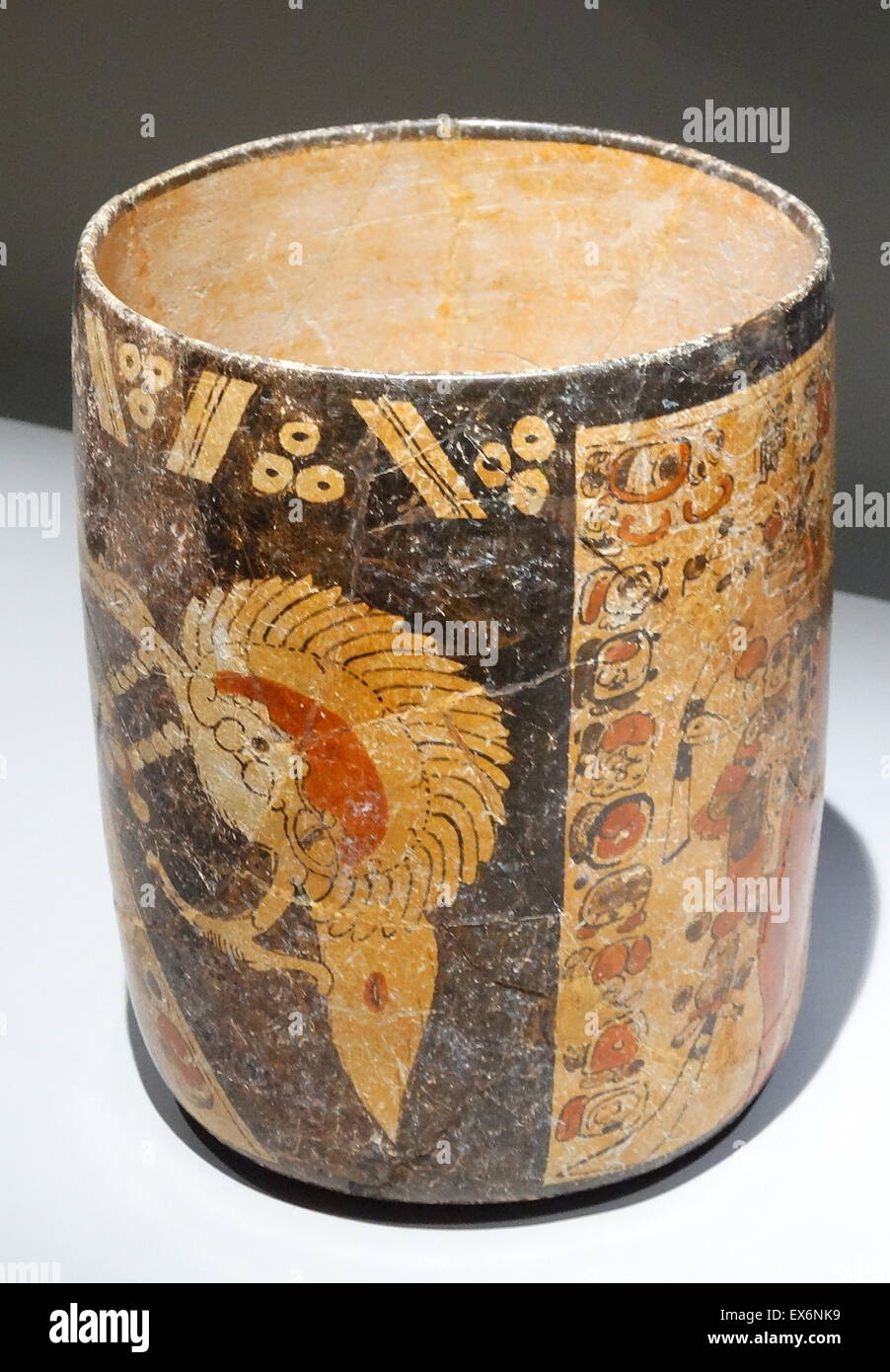 Straight-walled polychrome vase representing a double stage on a light and dark background. The dark background contains a representation of a bird while the light shows a male character richly dressed and standing beside a column and a band of decorative Stock Photo