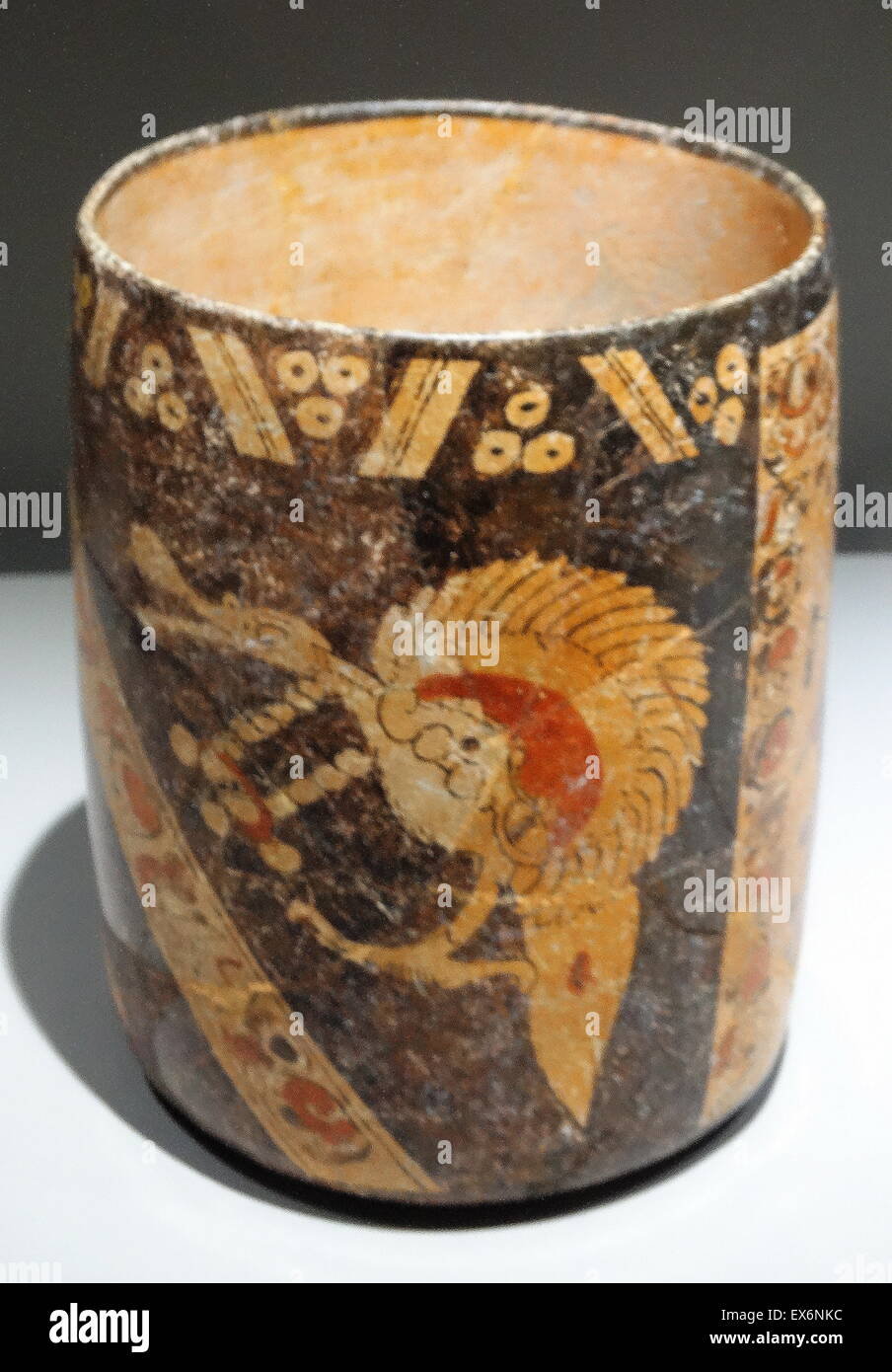 Straight-walled polychrome vase representing a double stage on a light and dark background. The dark background contains a representation of a bird while the light shows a male character richly dressed and standing beside a column and a band of decorative Stock Photo