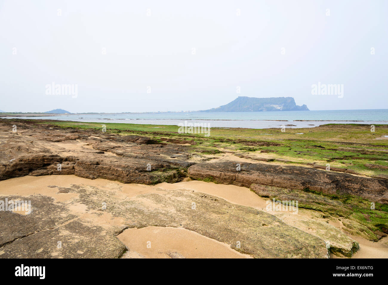 Landscape of Gwangchigi beach with Seongsan Ilchulbong, view from Olle trail No. 1. Gwangchigi is a unusual rocks beach. Stock Photo