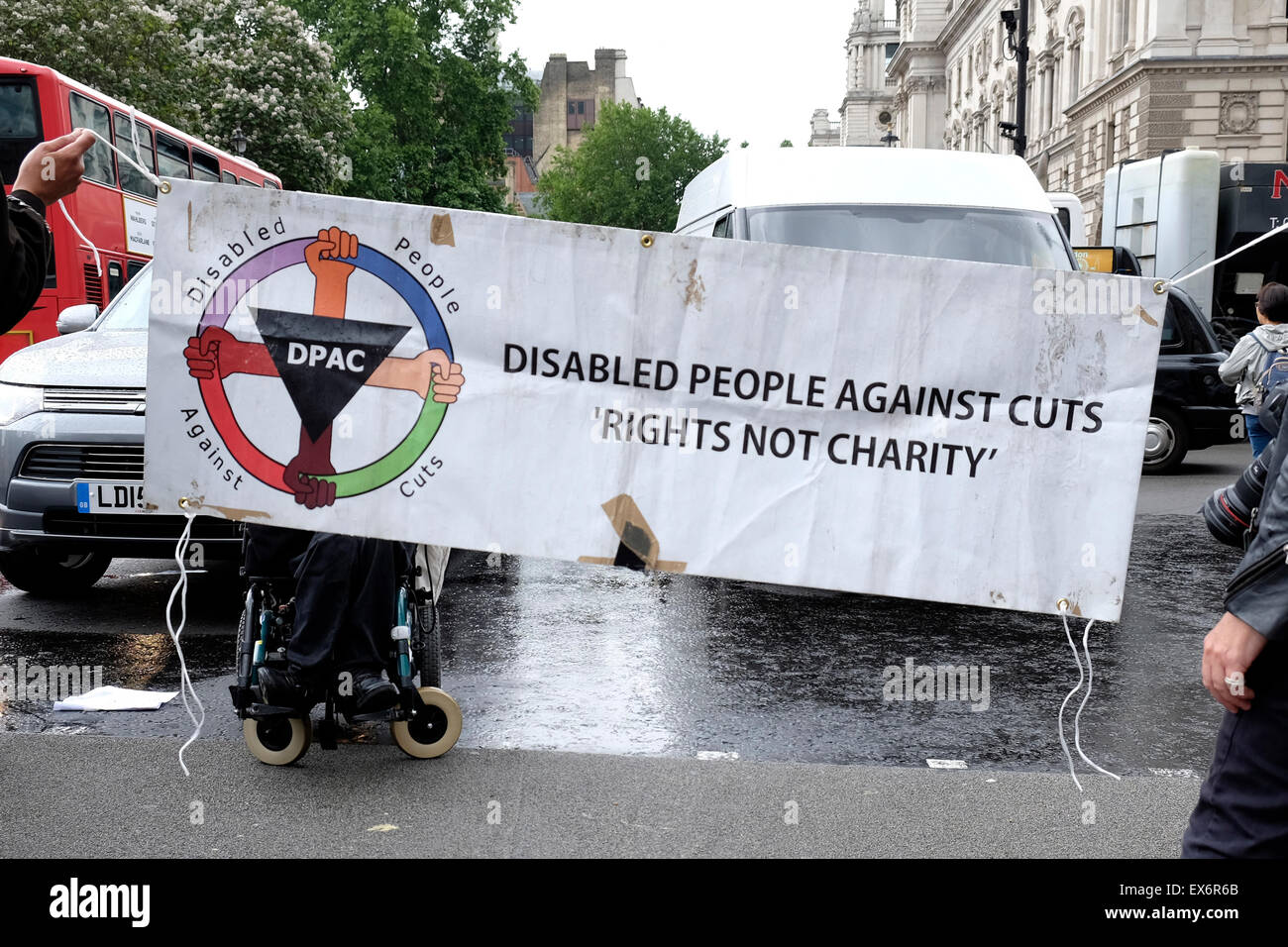 Wheelchair users hold a banner reading ' Disabled people against cuts, rights not charity' Stock Photo