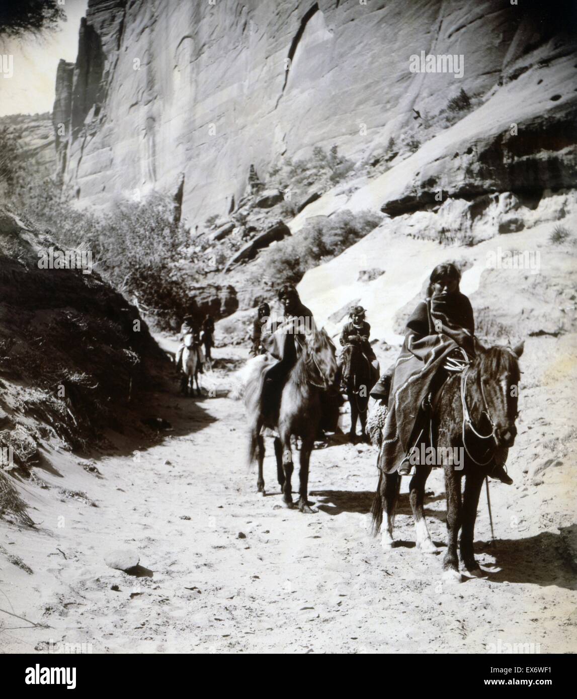 Photograph of a band of mounted Navahos passing through the canon. Photographed Edward S. Curtis (1868-1952) American ethnologist and photographer of the American West and of Native American peoples. Dated 1904 Stock Photo