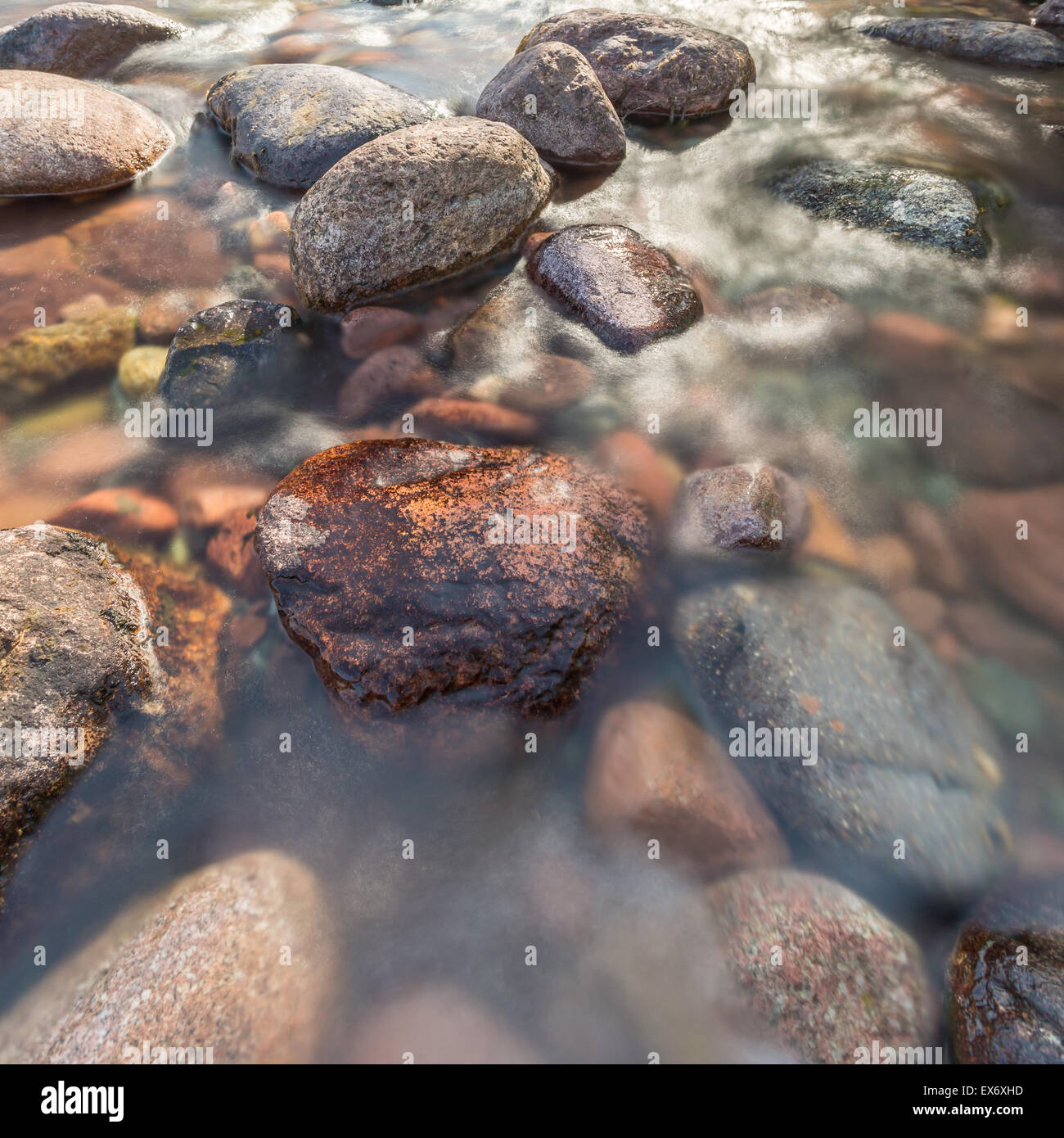 Calari Rocks water rushing past rocks in a fast flowing and crystal clear stream in ...