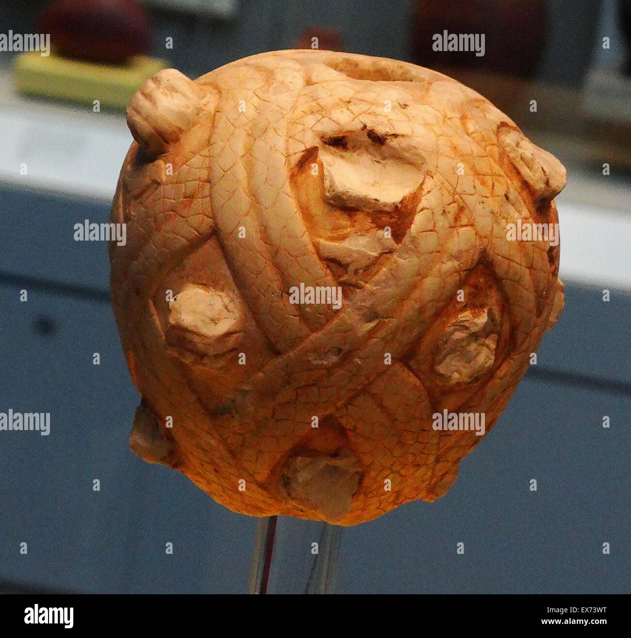 Decorated mace head. Clenched fists of the enemies trapped in the coils