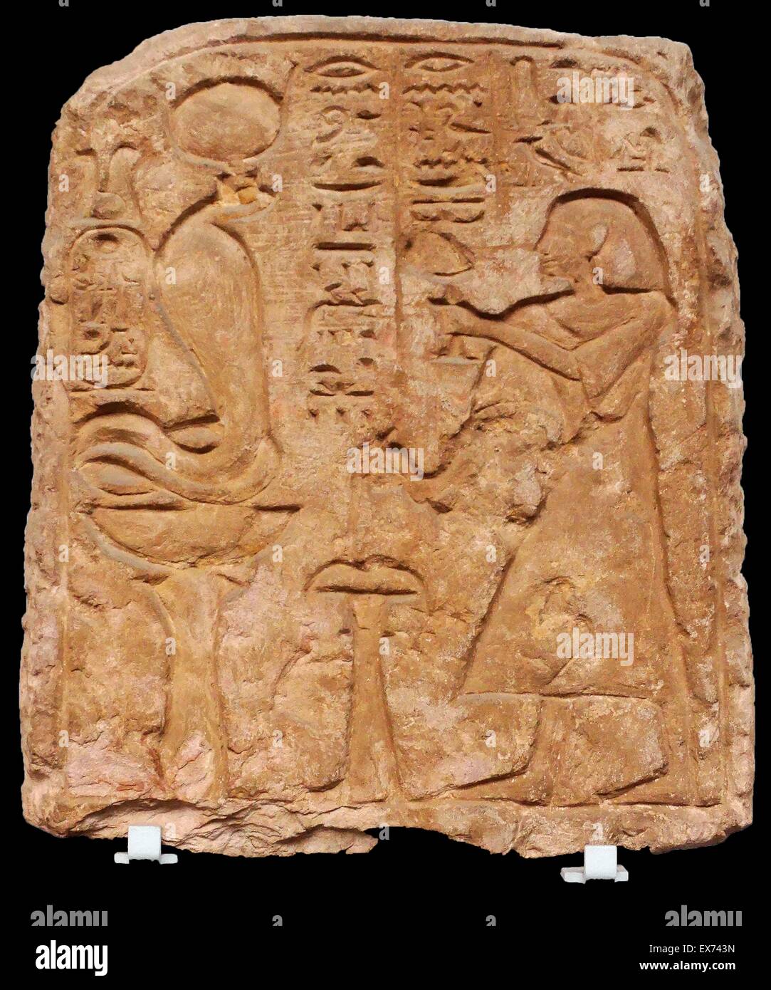 Sandstone stela of the Egyptian Viceroy of Kush, Setau. He is shown on the right pouring a libation over an altar and offering incense to the goddess Renenutet, represented as a serpent seated upon a basket on a stand. From Wadi Halfa 1200s BC (19th Dynas Stock Photo