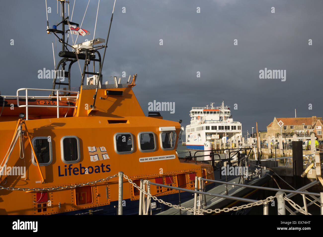 A RNLI (Royal National Lifeboat Institution) lifeboat and sea ferry at Yarmouth Terminal Jetty, Isle of Wight, UK Stock Photo