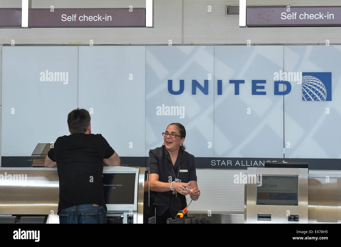 Washington, DC, USA. 8th July, 2015. A passenger checks in baggage with United Airlines at Ronald Reagan Washington National Airport in Washington, DC, the United States, on July 8, 2015. United Airlines (UA) resumed flights at all airports that had been grounded Wednesday morning for about two hours due to a computer glitch, according to the U.S. Federal Aviation Administration (FAA). Credit:  Bao Dandan/Xinhua/Alamy Live News Stock Photo