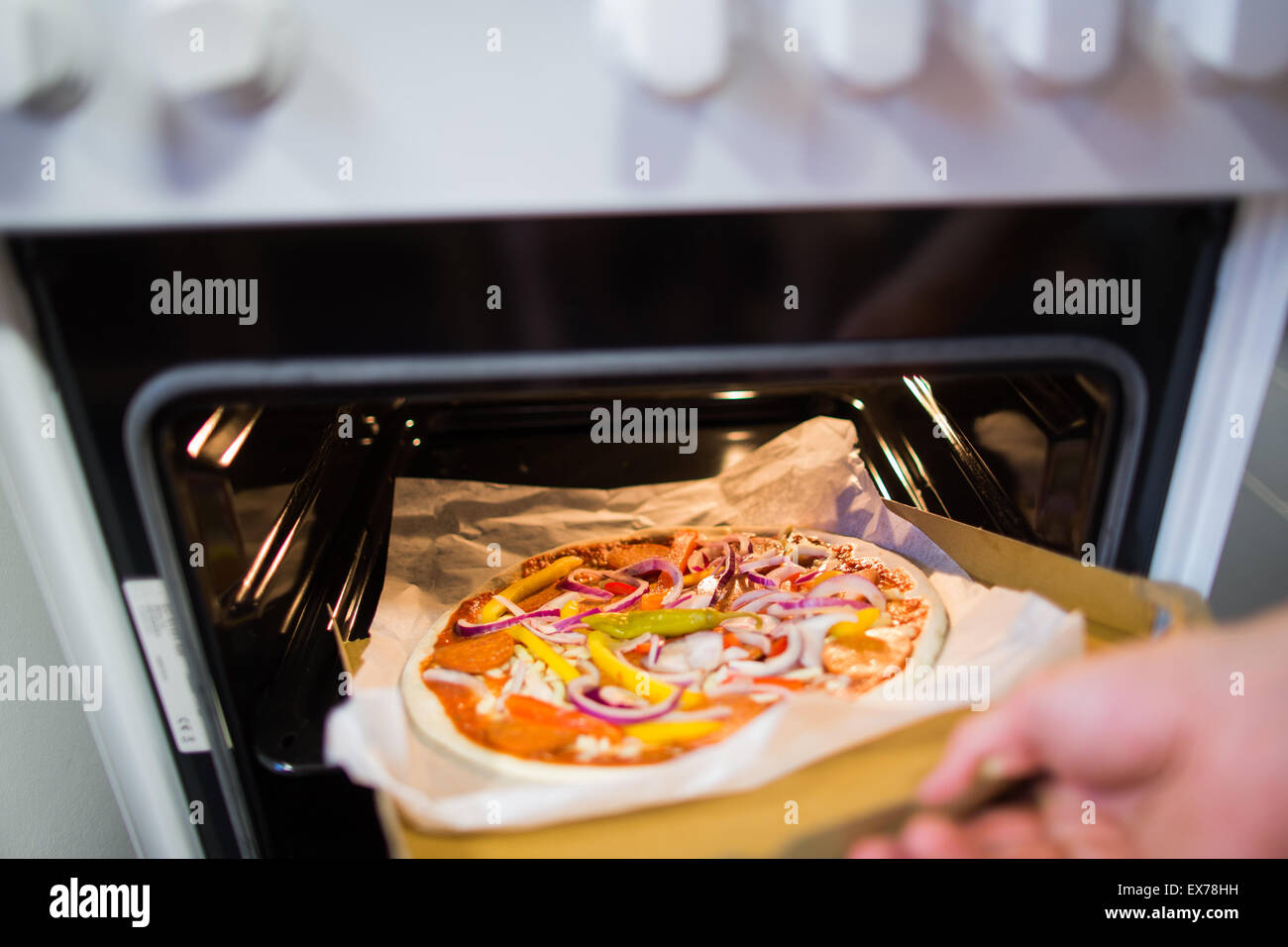 Bonn, Germany. 7th July, 2015. A raw pizza is put into the oven at the Vapiano headquaters in Bonn, Germany, 7 July 2015. The restaurant chain hopes in the future to deliver 'Homebaked Pizza' - pizza that the customer bakes in the oven themselves. Photo: Rolf Vennenbernd/dpa/Alamy Live News Stock Photo