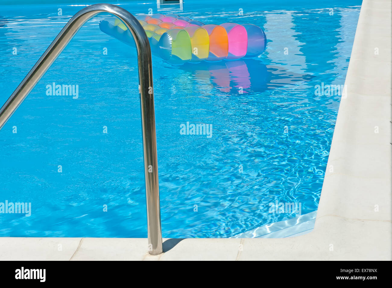 Corner of the swimming pool with blue water and colorful inflatable ...