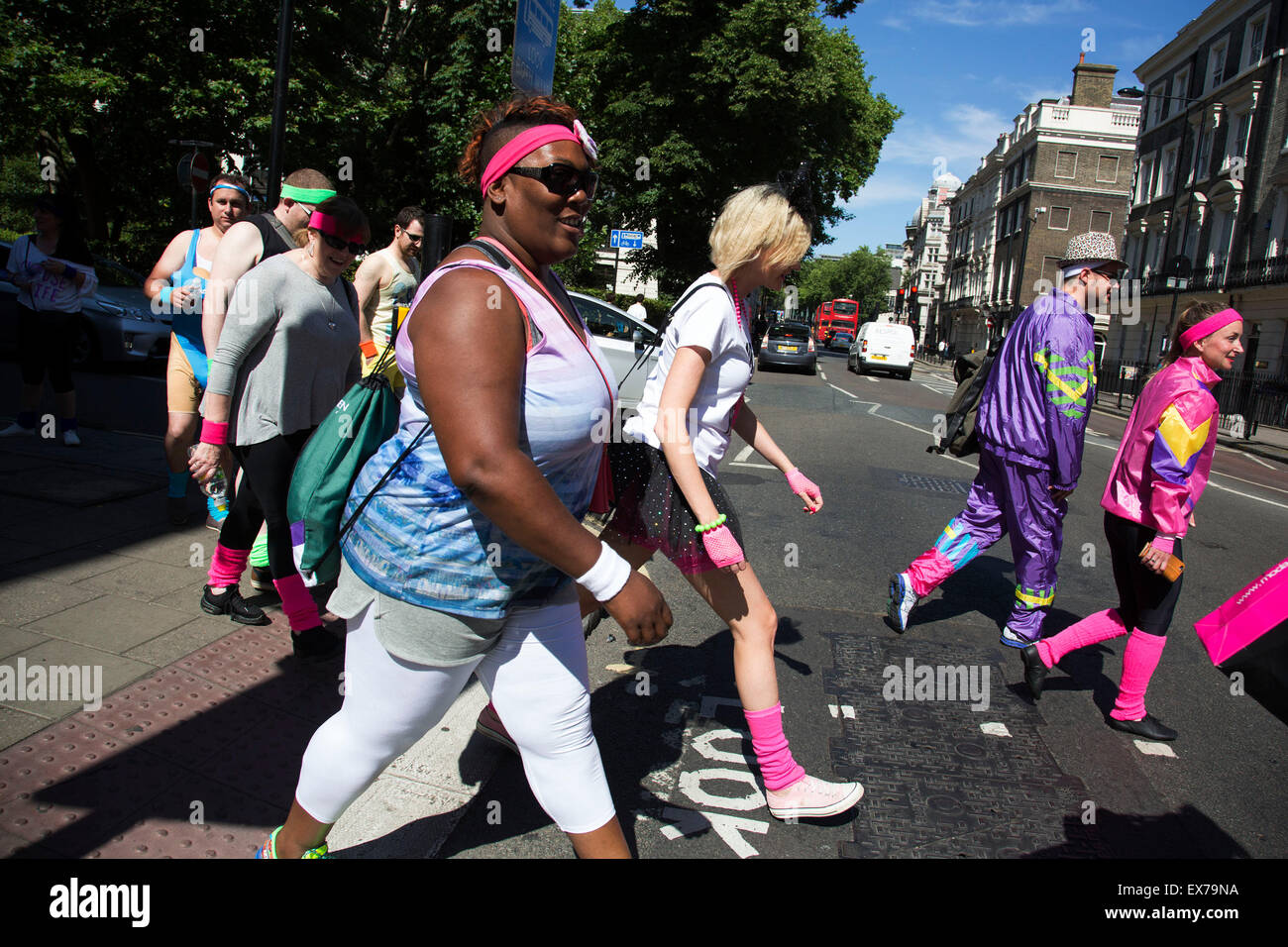 Summertime in London, England, UK. Group of friends out and about dressed up in 1980s brightly coloured clothing. It is a common sight to see groups like this dressing up to enjoy a party or celebration of some kind. Stock Photo
