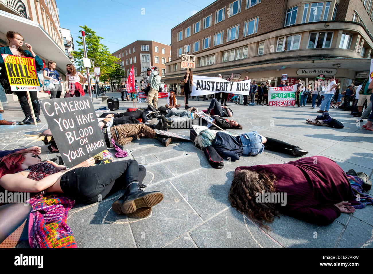 Exeter, Devon, UK. 8th July, 2015. Anti-austerity demonstrators play dead during the Exeter Budget Day Action #AusterityKills in Exeter City Centre on july 8th, 2015 in Bedford Square, Exeter, UK Credit:  Clive Chilvers/Alamy Live News Stock Photo