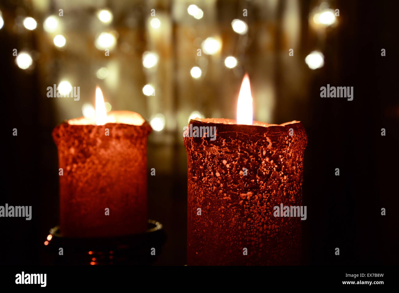 Two orange candles over christmas lights Stock Photo Alamy