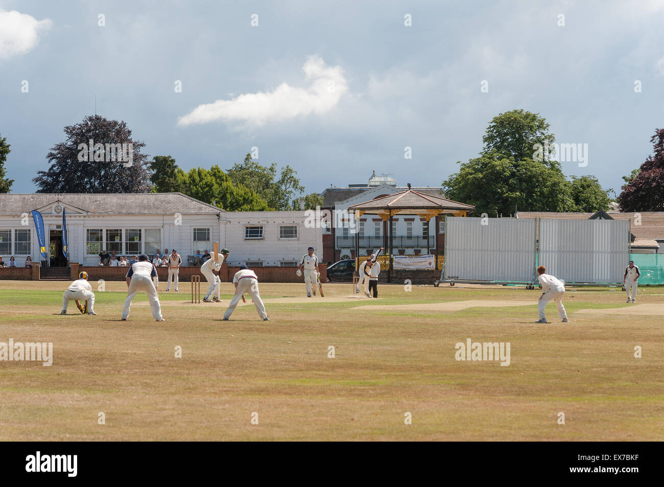 Typically British a game of cricket played on The Vine Sevenoaks surrounded by the 7 oaks with north downs and club house Stock Photo
