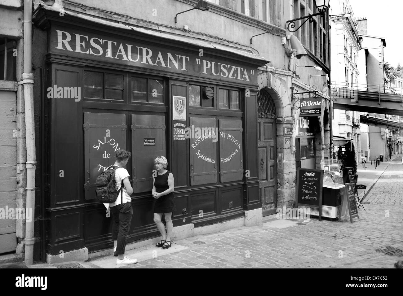 Woman talking with young man outside a closed restaurant 'Puszta' in Lyon France Stock Photo