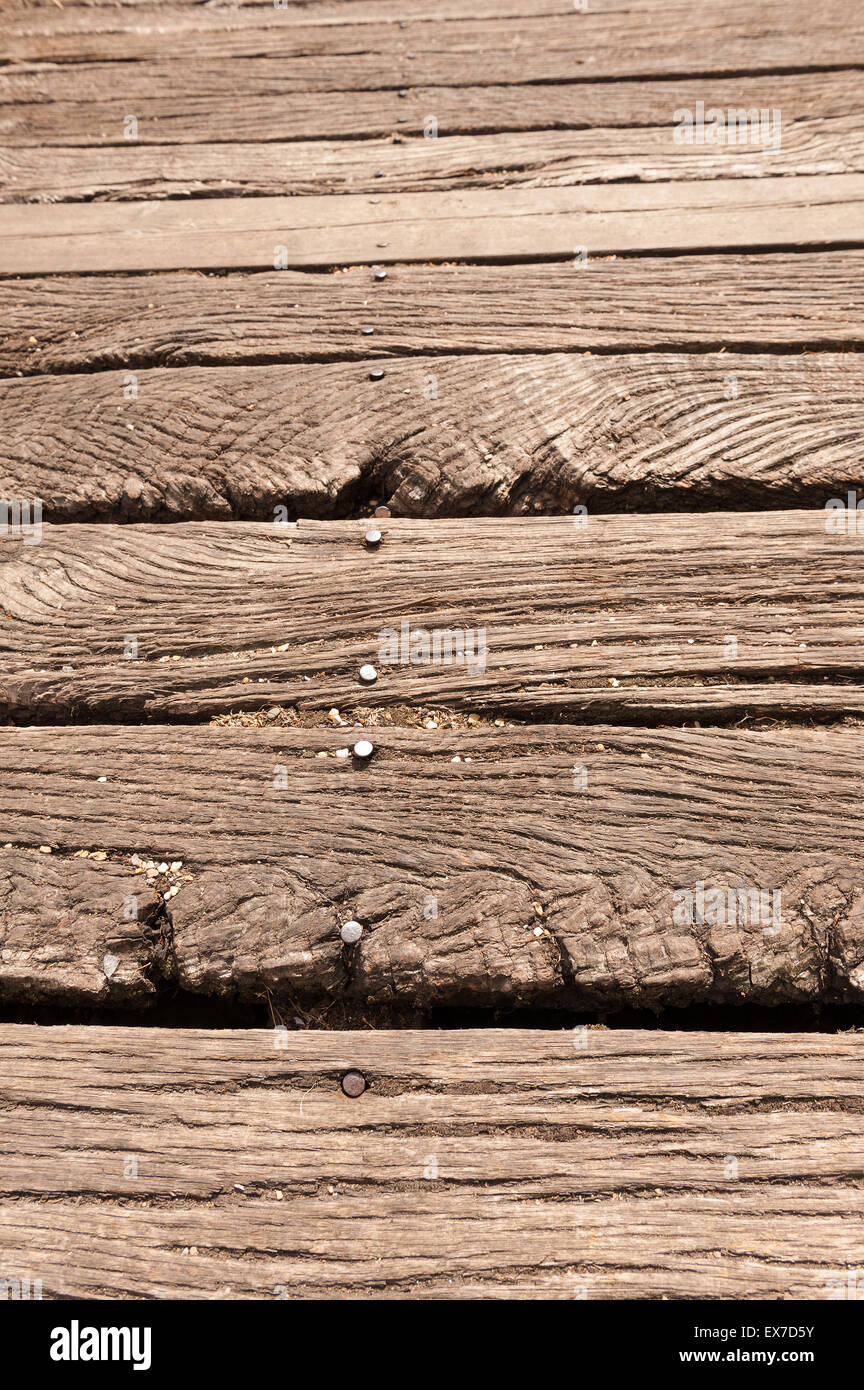 Gnarled weathered old English oak timber four by two inch beams used for deteriorating bridge footpath showing worn grain Stock Photo