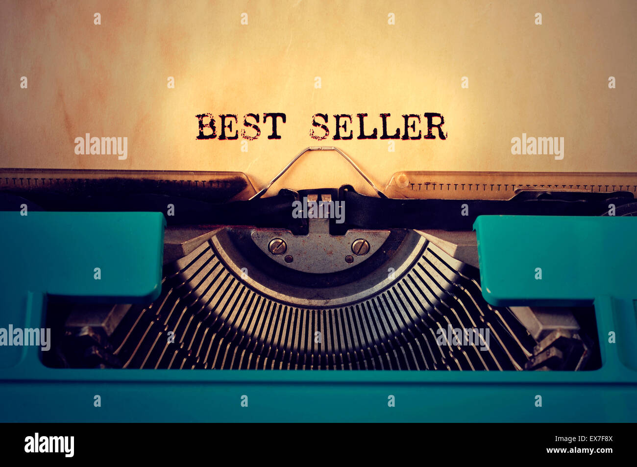 closeup of a blue retro typewritter and the text best seller written with it in a yellowish foil Stock Photo