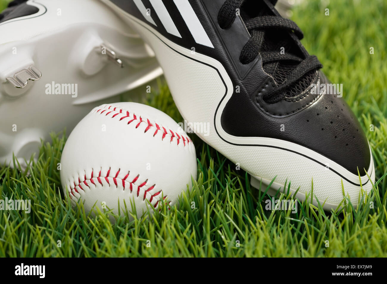 Baseball shoes and ball on grass Stock Photo - Alamy