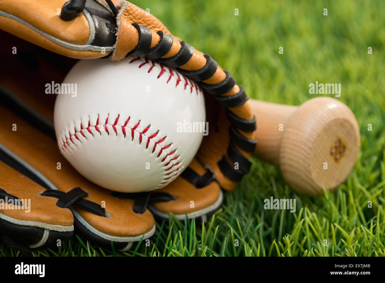 Ball inside catchers mitt and bat on grass Stock Photo Alamy