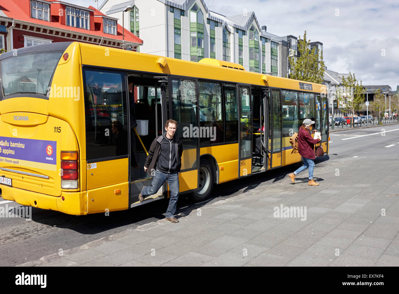 passengers getting off Reykjavik yellow local bus transport iceland