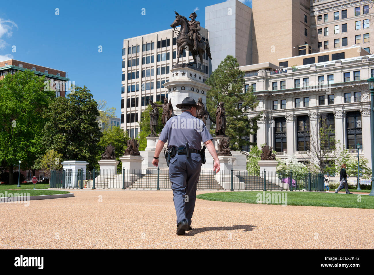 Police officer walking towards the George Washington equestrian monument, State Capitol, Richmond, Virginia, USA Stock Photo