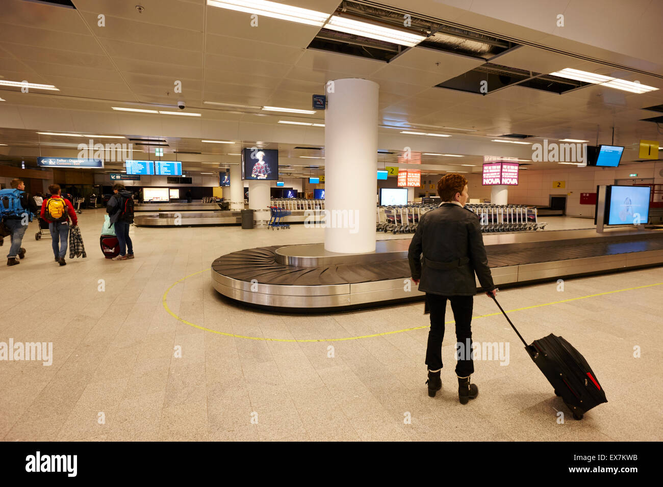 passengers at baggage carousel Keflavik airport terminal building exterior Iceland Stock Photo