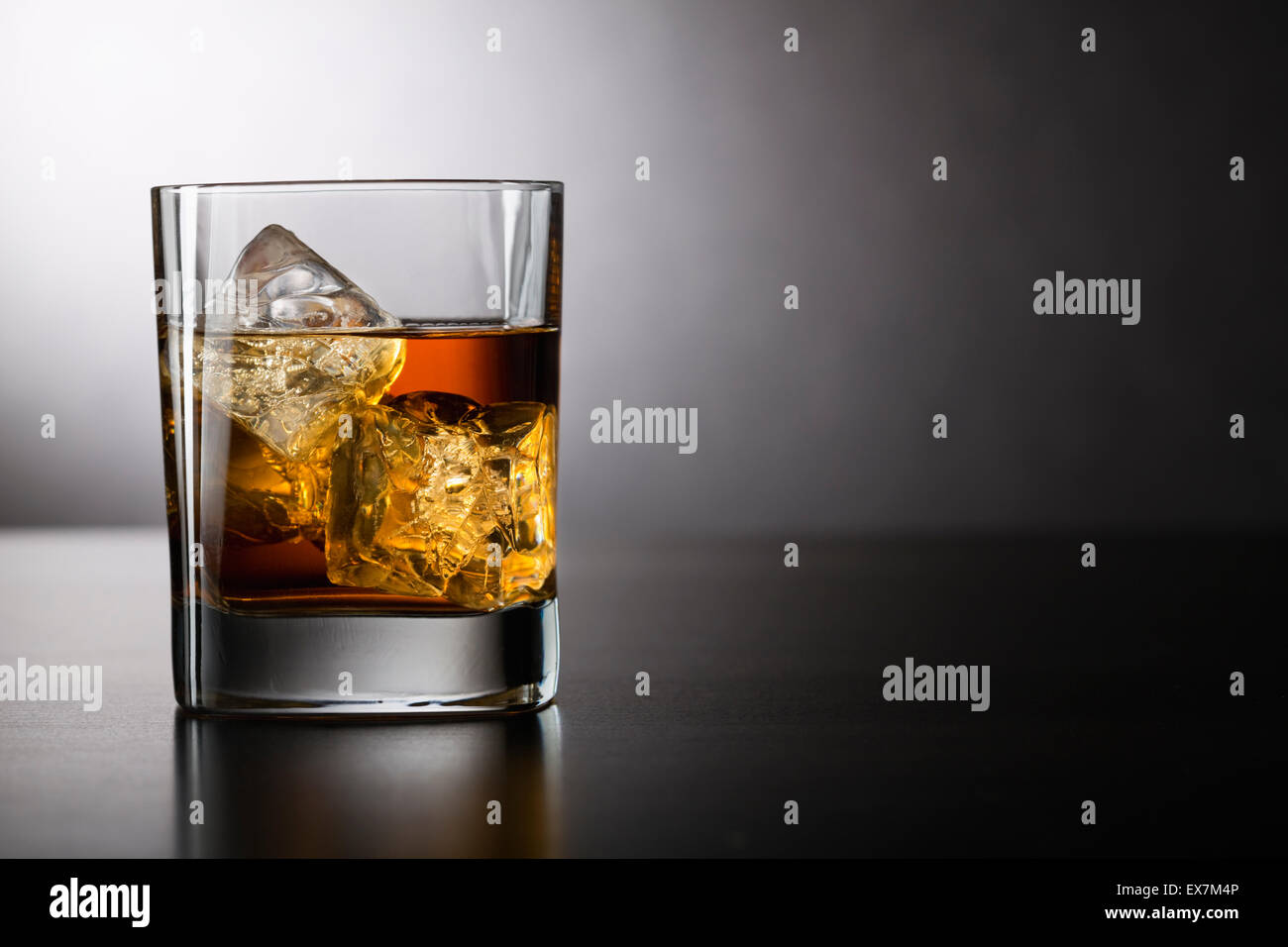 Glass of whiskey with ice Stock Photo