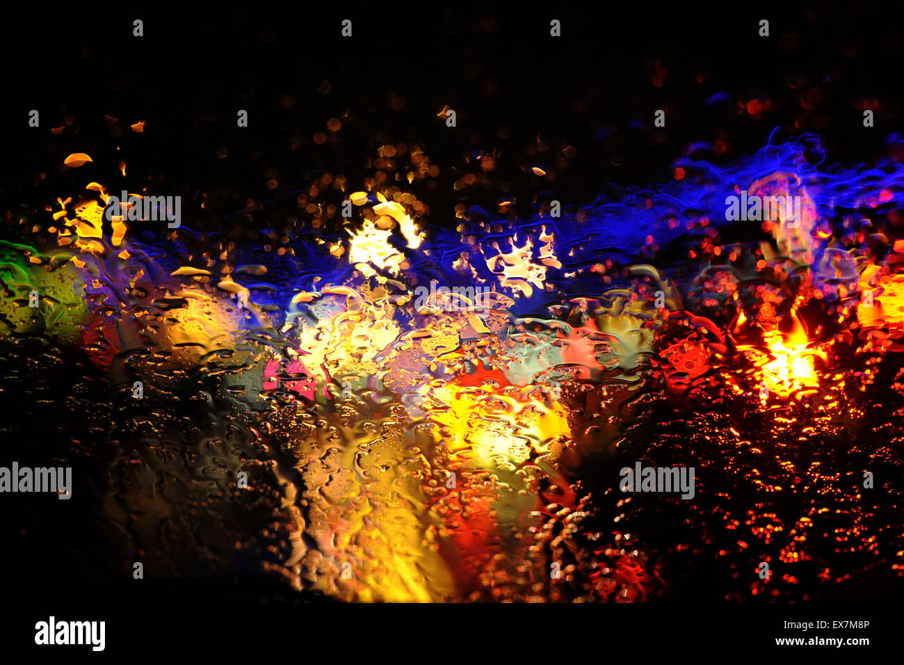 A windscreen showing traffic and brake lights during rainy weather on a motorway. Stock Photo
