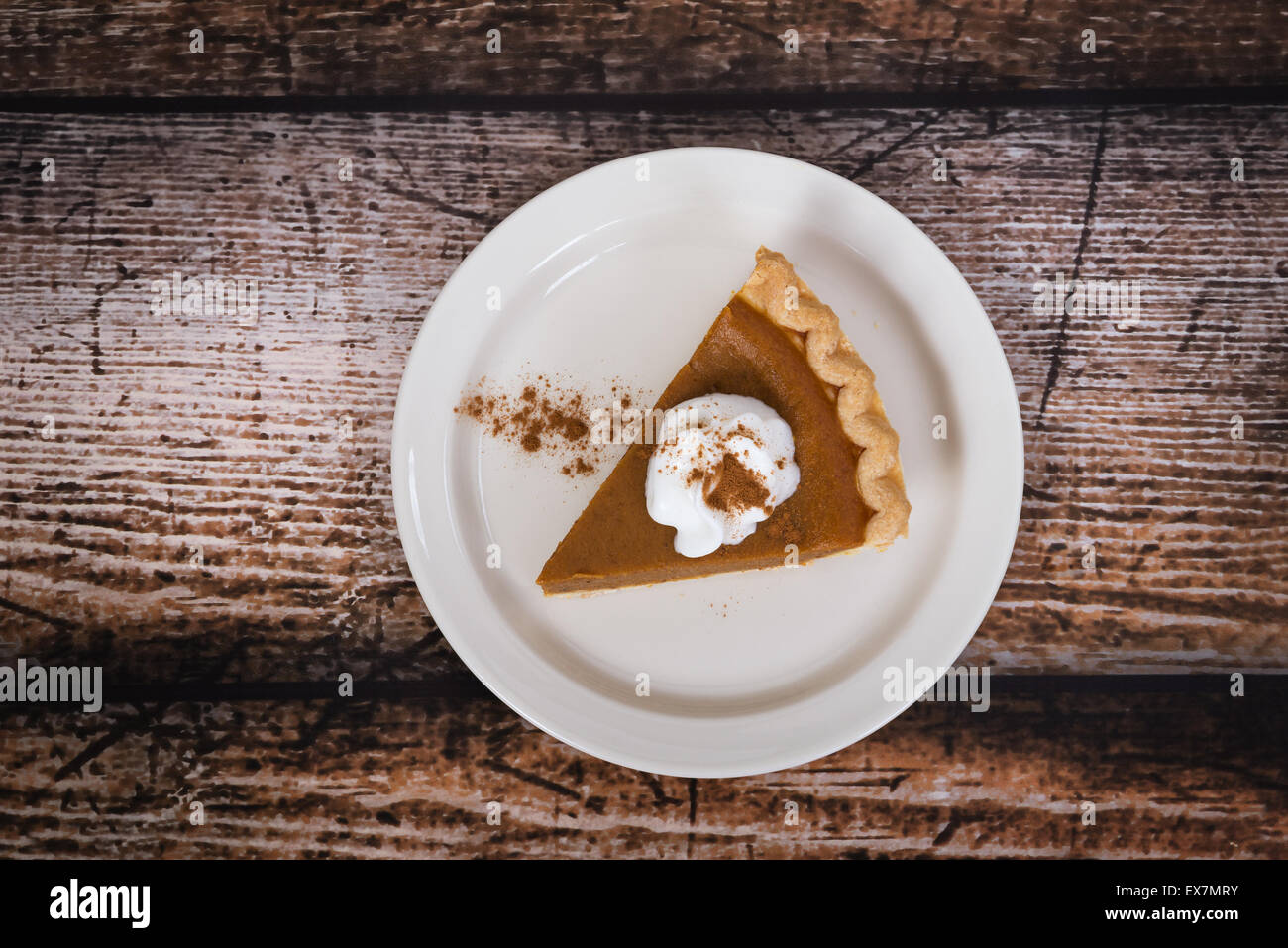 Slice of a pumpkin pie on wooden vintage table Stock Photo