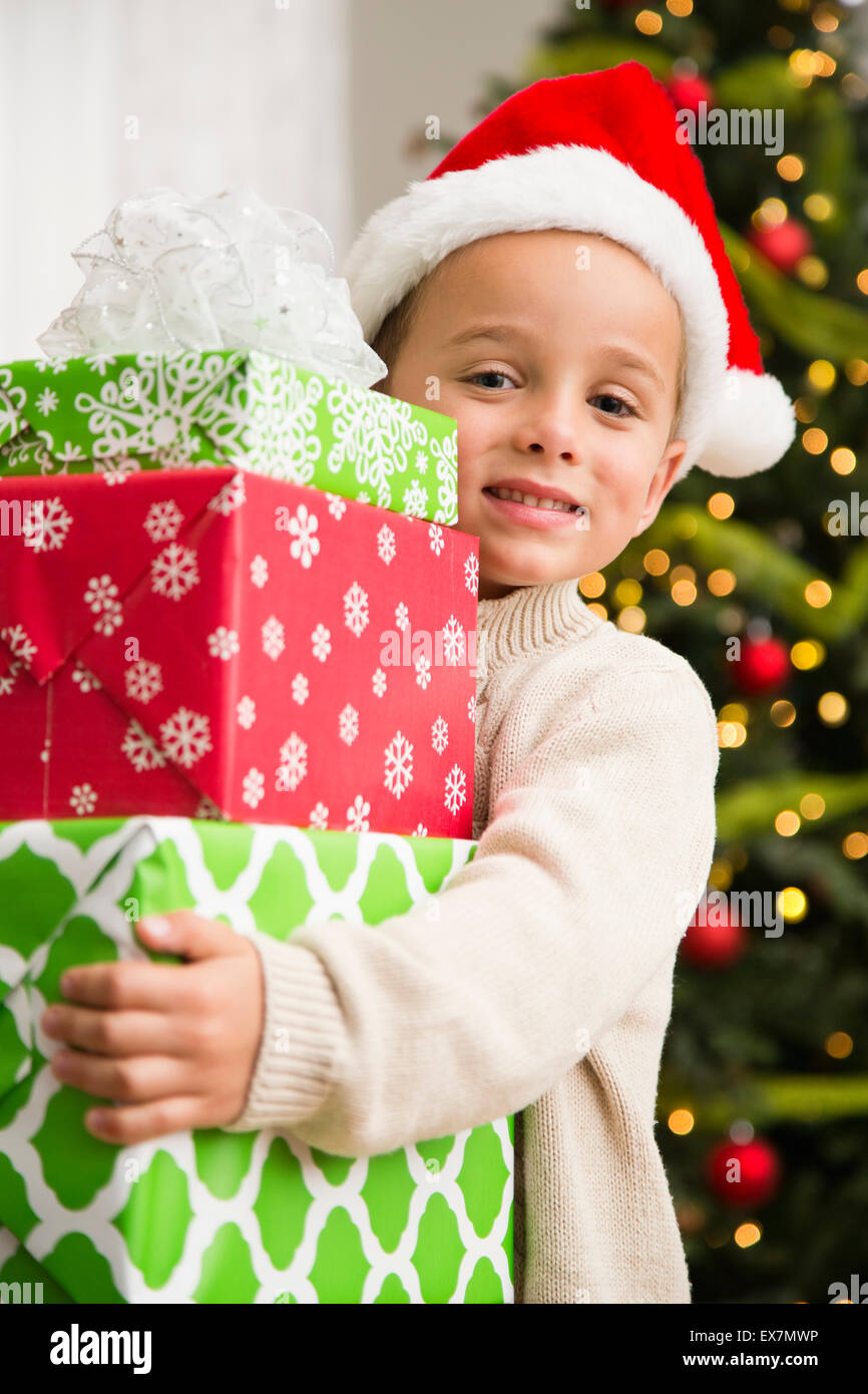 Boy (6-7) holding stack of Christmas presents Stock Photo