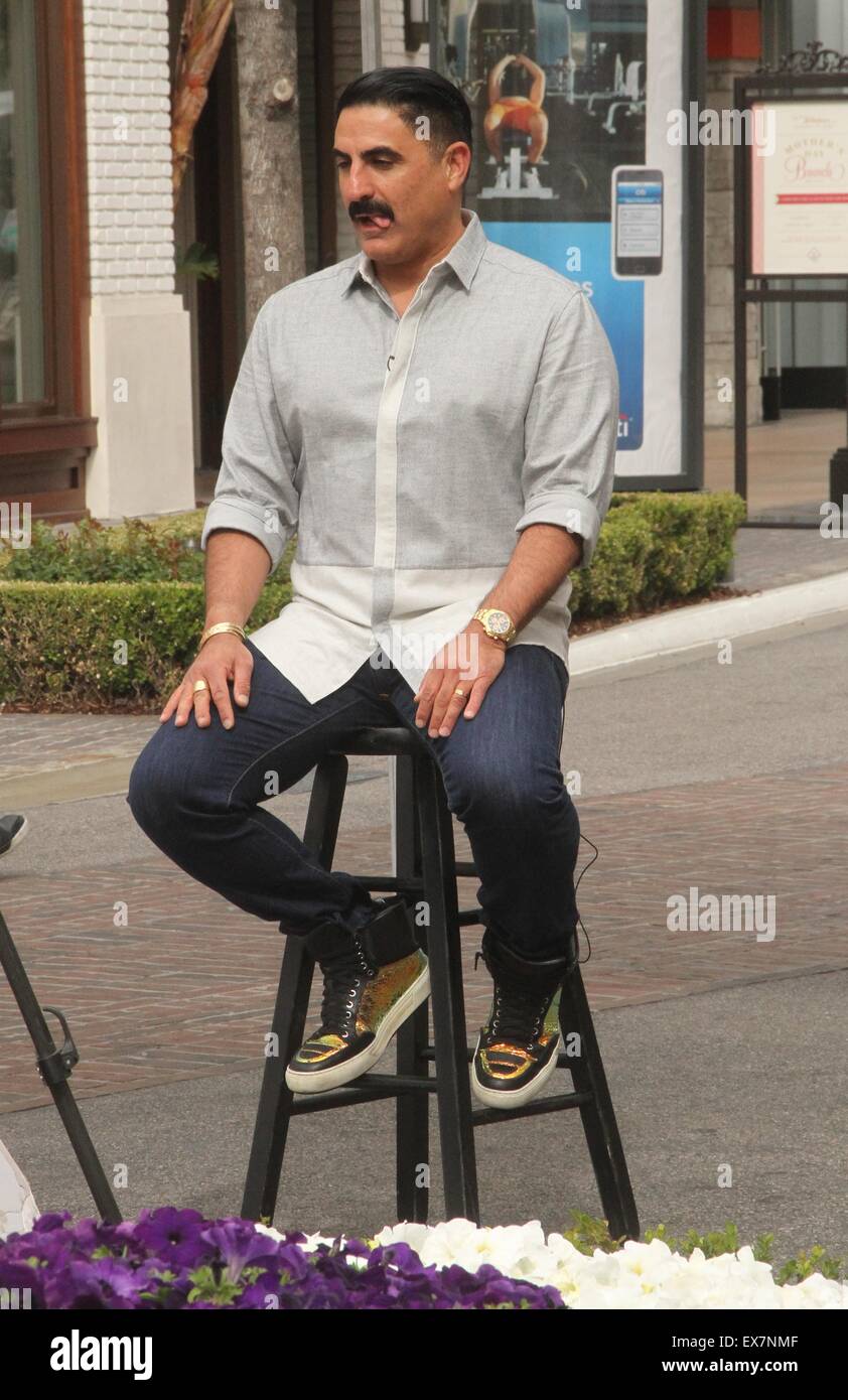 Shahs of Sunset actor, Reza Farahan sitting on a stool, does an ...