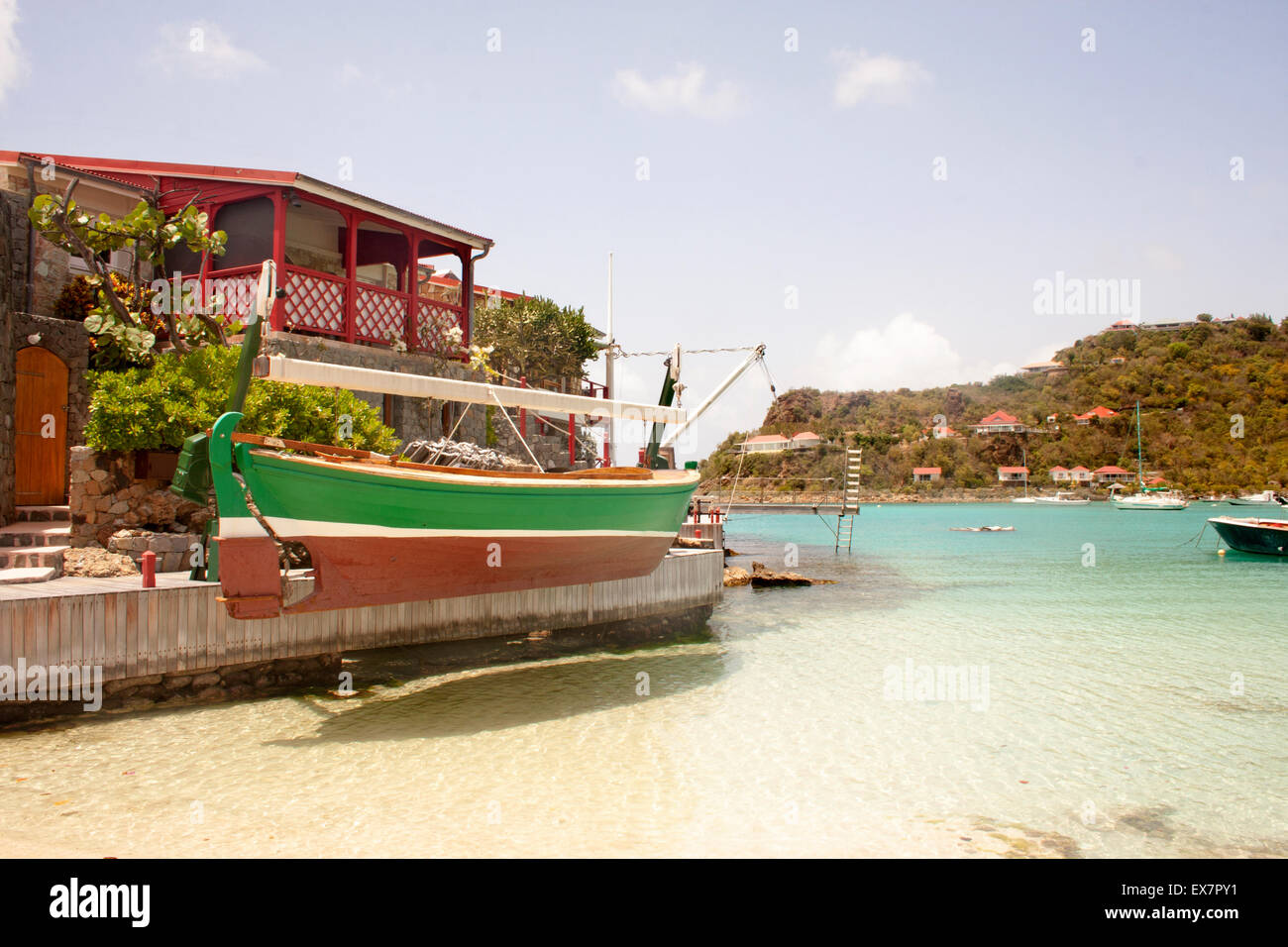 A beautiful green wooden boat docked at the famous Eden Rock Hotel in St. Barts Stock Photo