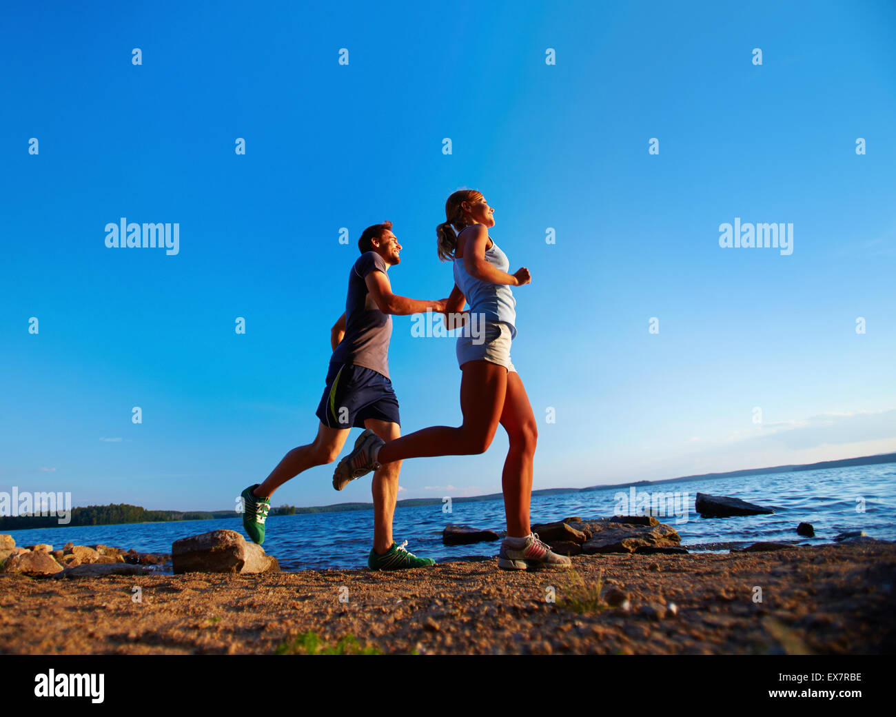 Happy couple running down sea shore Stock Photo