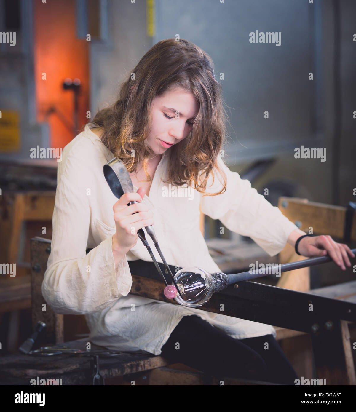 A working girl in the hot shop of a glass work Stock Photo
