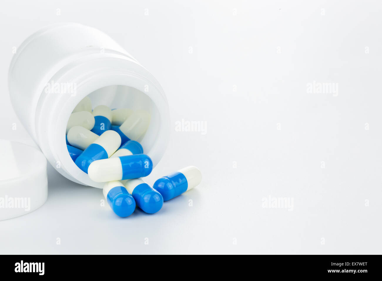 Blue and white pills an pill bottle on white background (Isolated Stock