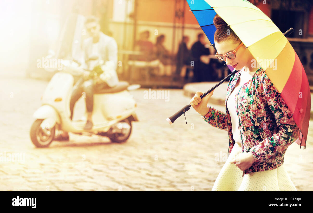 Portrait of a young woman holding a colorful umbrella Stock Photo - Alamy