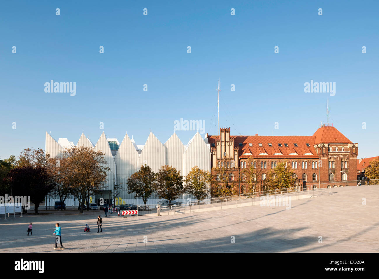 Distant view towards philharmonic hall and adjacent building with street. Szczecin Philharmonic Hall, Szczecin, Poland. Architec Stock Photo