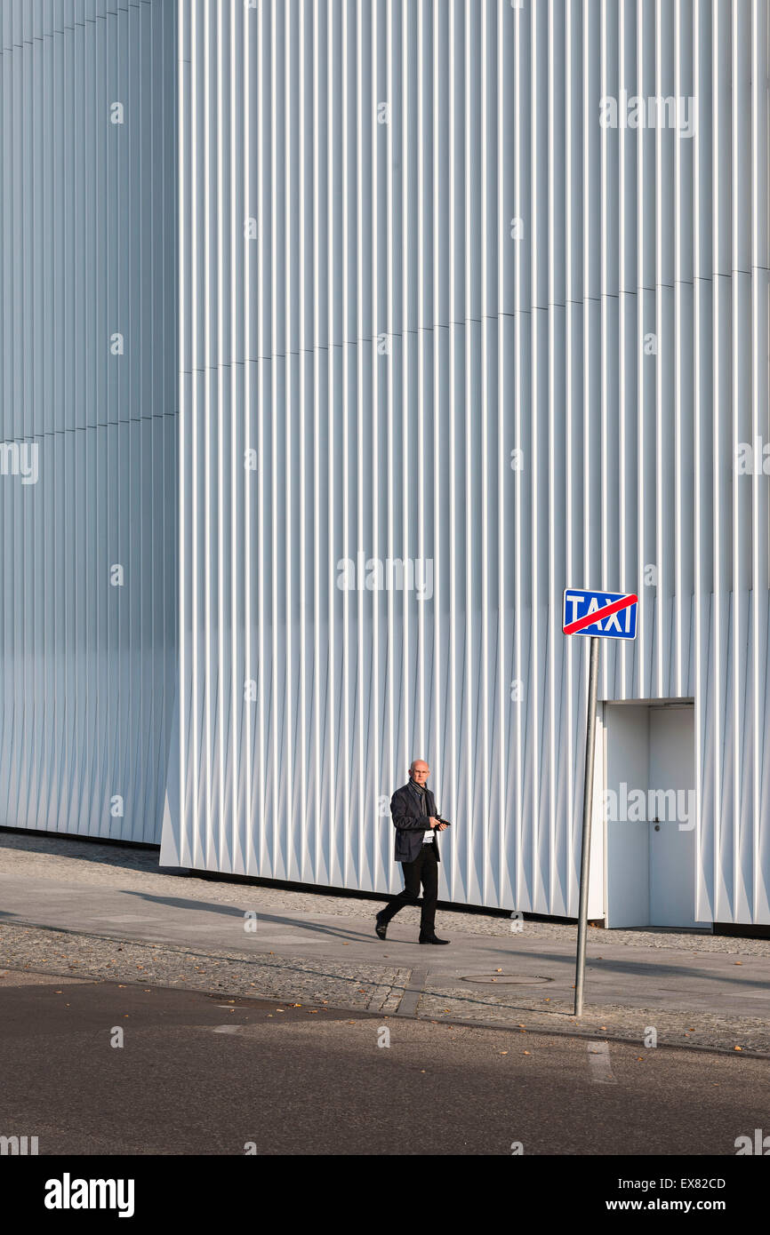 Facade with walkway and passerby. Szczecin Philharmonic Hall, Szczecin, Poland. Architect: Estudio Barozzi Veiga, 2014. Stock Photo