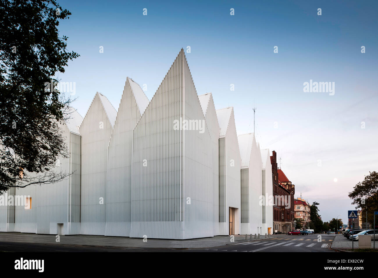 Corner elevation with zigzag roof profile against dusk sky. Szczecin Philharmonic Hall, Szczecin, Poland. Architect: Estudio Bar Stock Photo