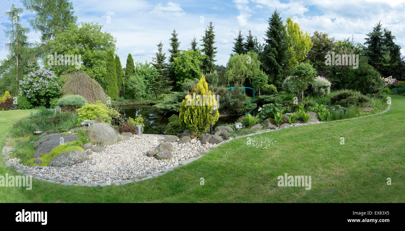 Beautiful spring garden design, with conifer trees, green grass and ...