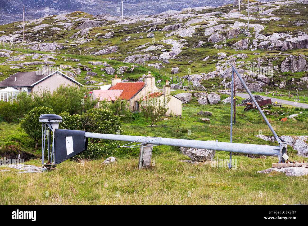 Barren, rugged scenery on the Golden Road on the East side of the Isle of Harris, Outer Hebrides, Scotland, UK, with a broken down wind turbine. Stock Photo