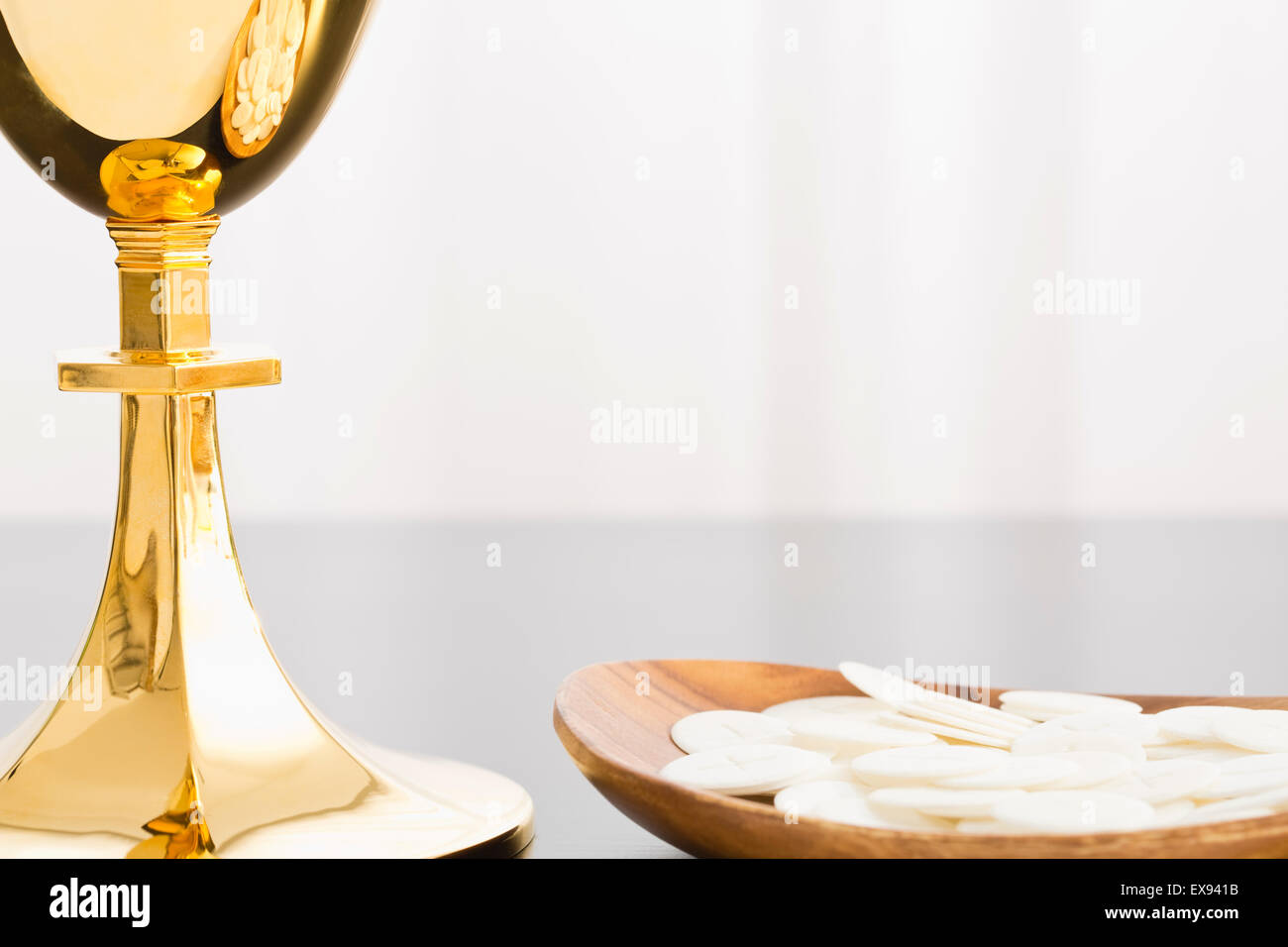 Christian holy communion, gold chalice and communion wafer on plate Stock Photo
