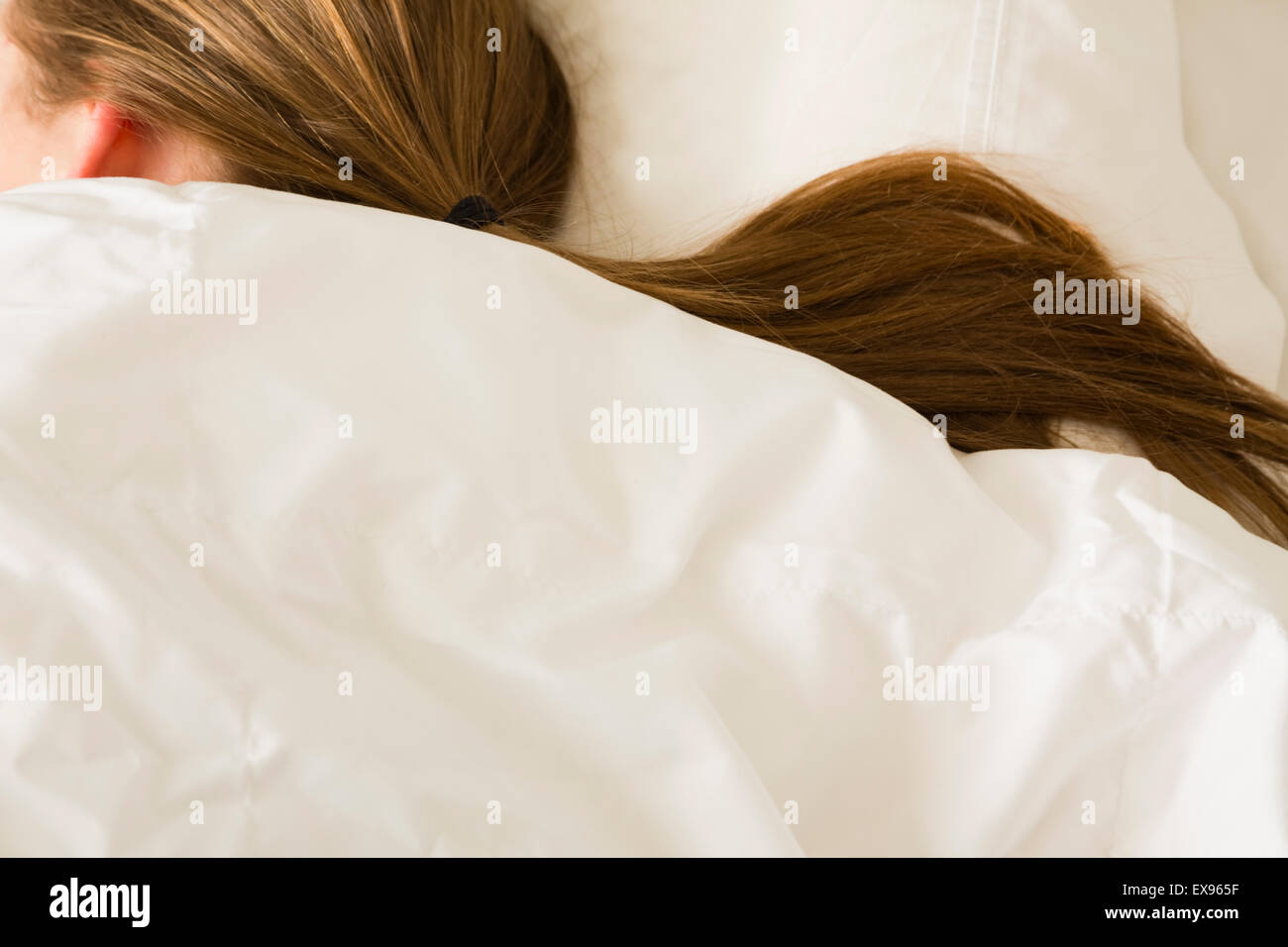 Female with ponytail sleeping in white bedding Stock Photo Alamy