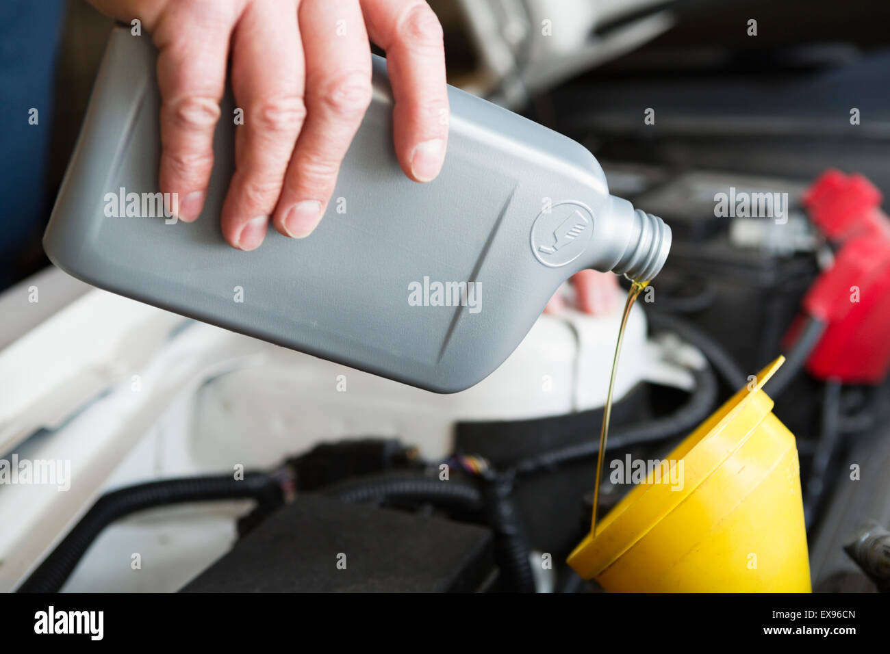 Man pouring car oil from plastic bottle Stock Photo