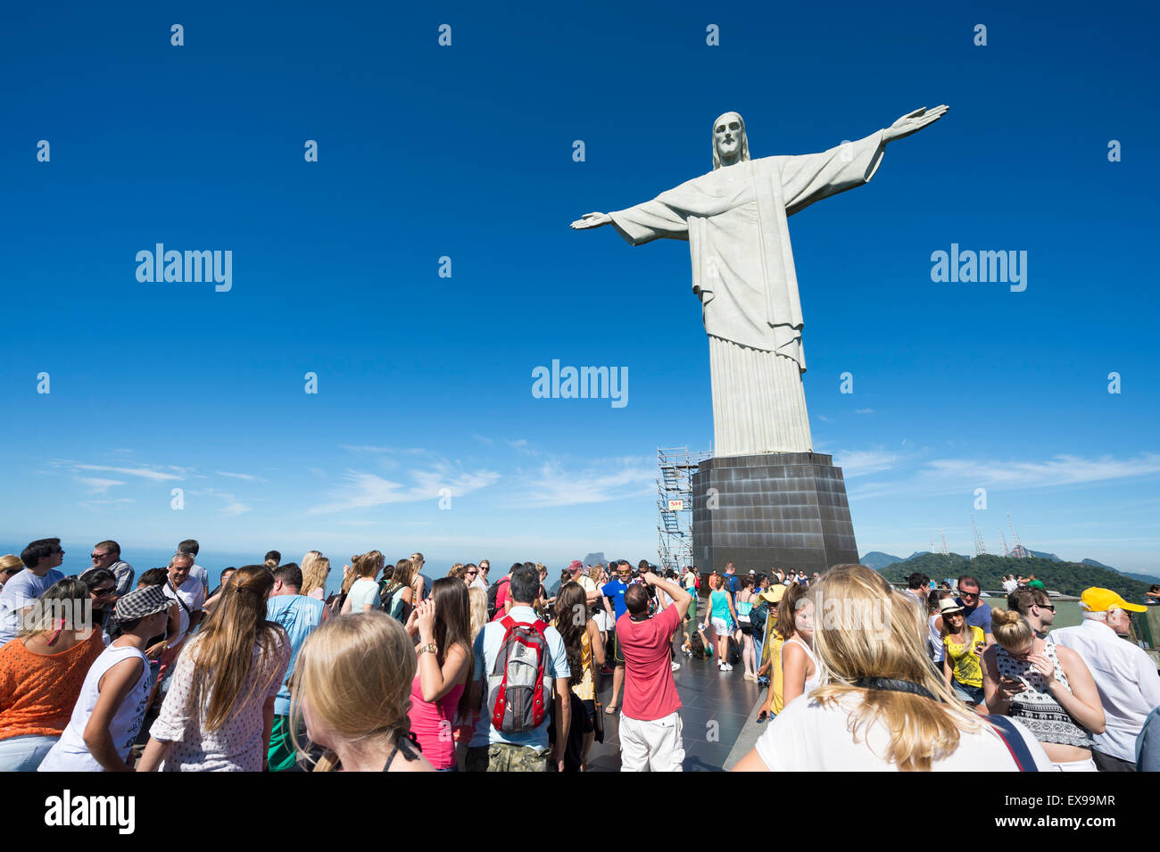 RIO DE JANEIRO, BRAZIL - MARCH 05, 2015: Groups of tourists take pictures on a bright morning at the Christ the Redeemer statue. Stock Photo