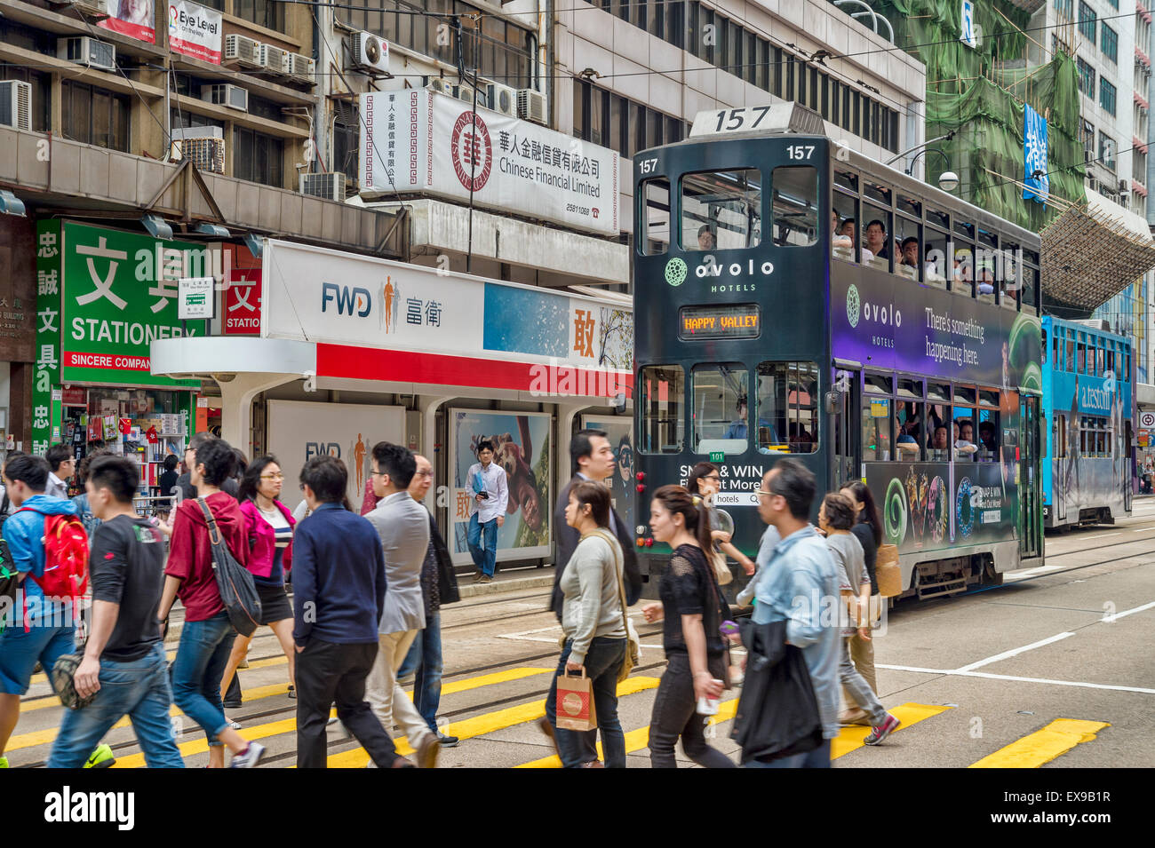 Commuters Crossing Busy Hong Kong Street, with a tram in the background Stock Photo