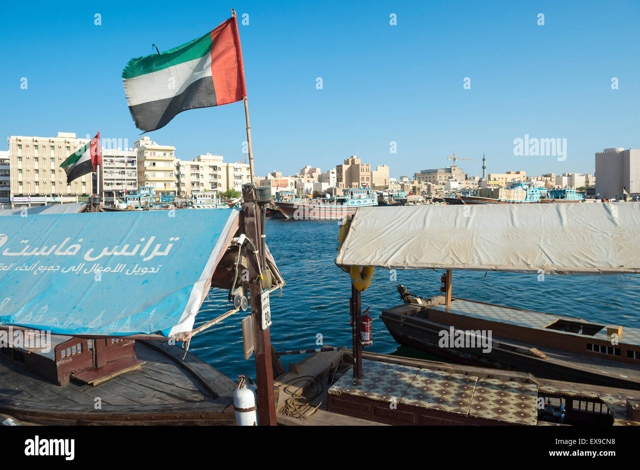 DUBAI, UAE OCTOBER 22, 2014 UAE flag on the Bur Dubai side of the Creek flies over a pier for