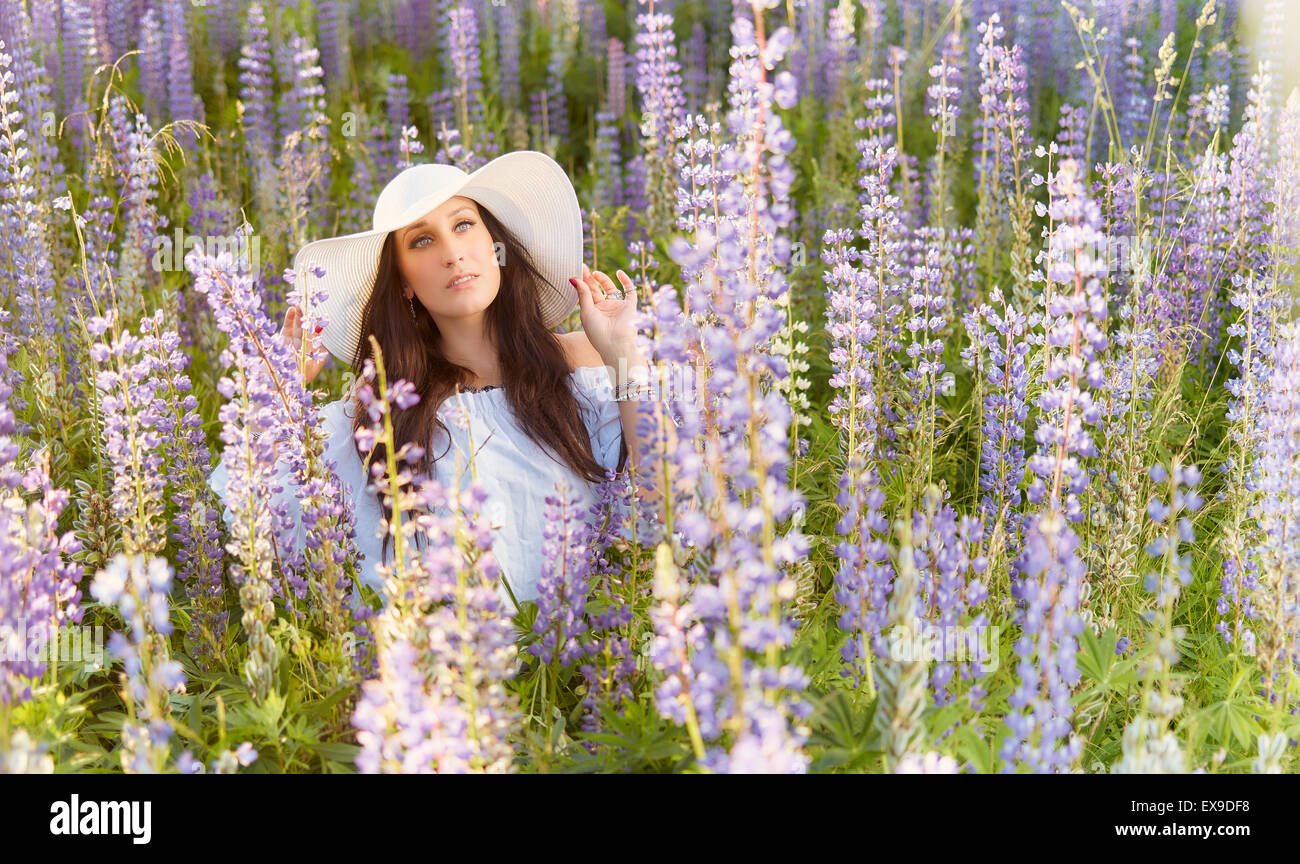 Fashionable young woman wearing a white hat and shirt, summery meadow Stock Photo