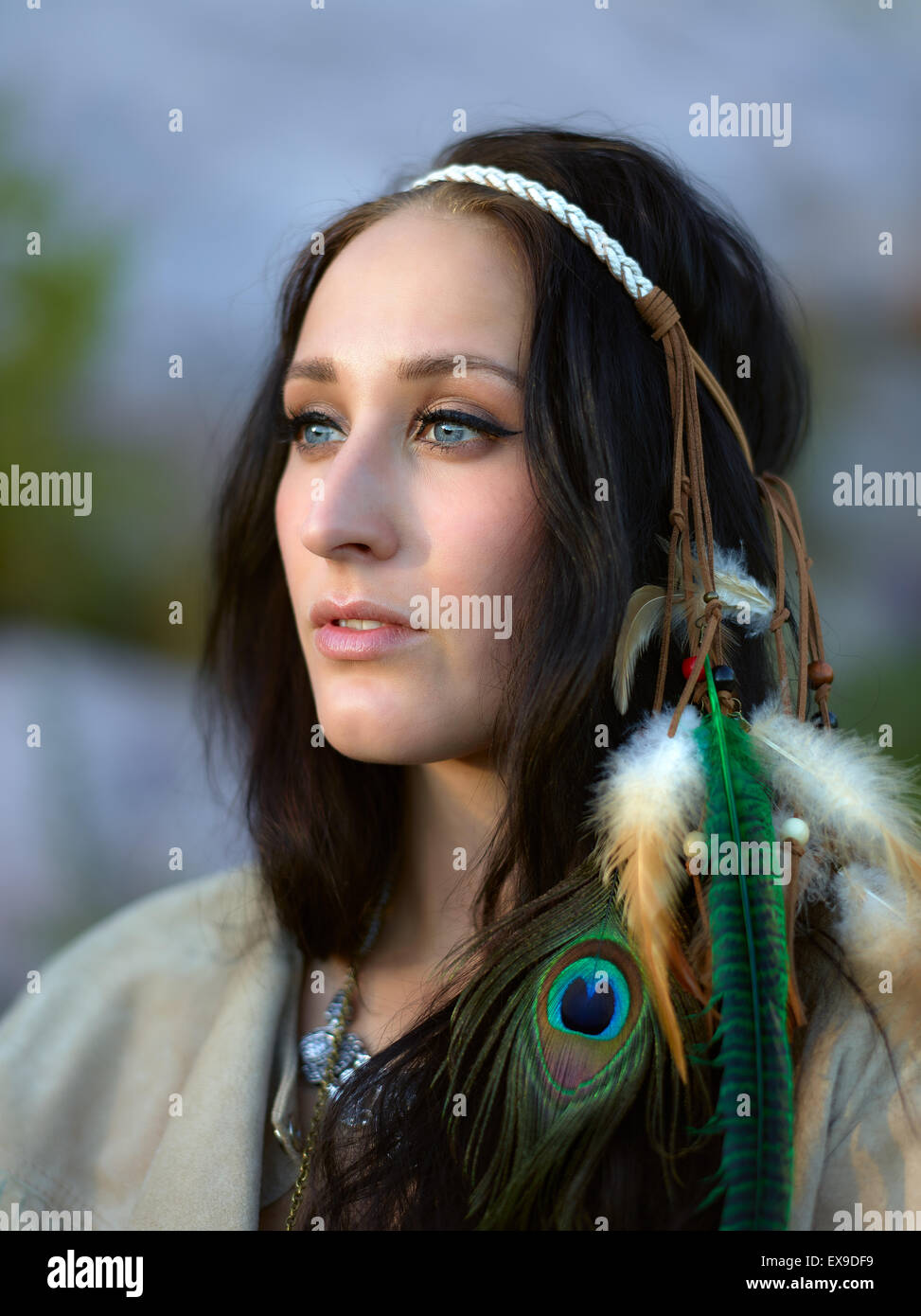 Attractive young woman wearing a feather headpiece, summer evening Stock Photo