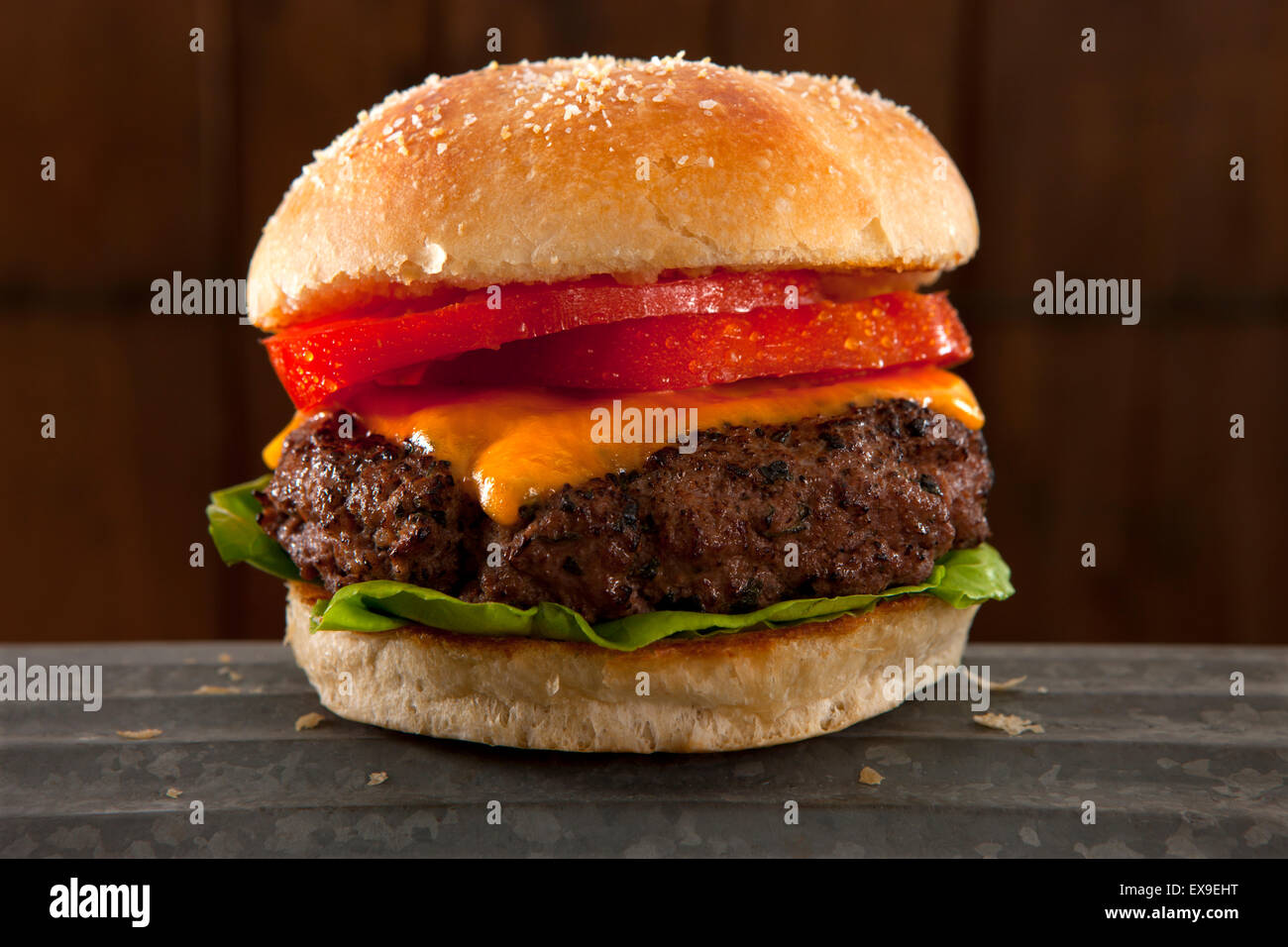 Studio photograph of organic beef cheddar cheese burger with tomato and